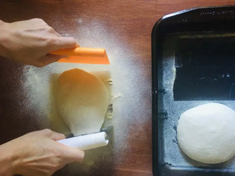 dropping a pizza dough onto semolina flour