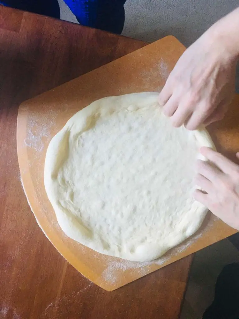 neapolitan pizza dough shaped open Why Is My Pizza Crust Too Hard? How To Make Pizza Crust Softer