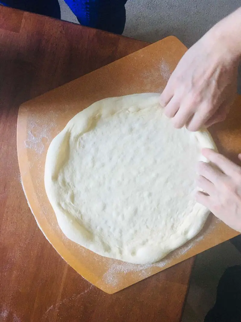 How To Make Neapolitan Pizza At Home - Step By Step Guide 5 stretching a pizza dough on a pizza peel
