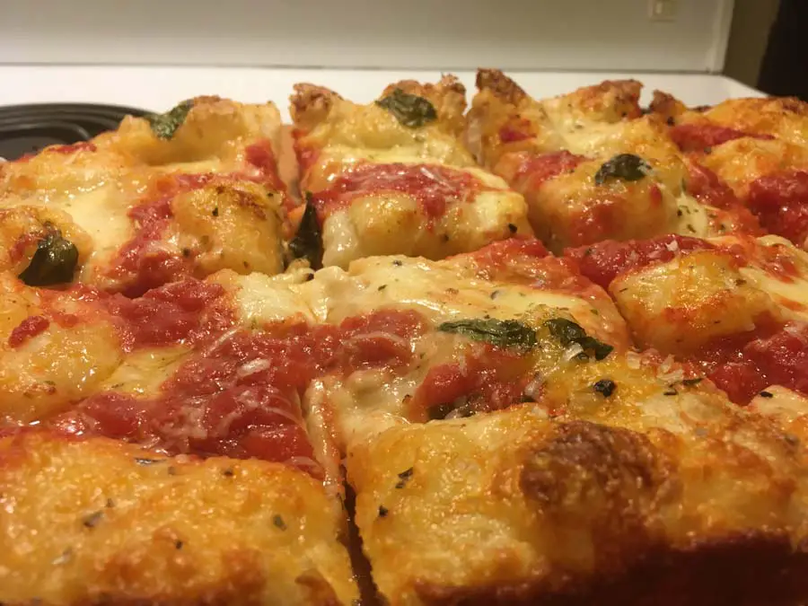 About Domenic 3 panned pizza angled About Domenic