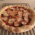 How To Use A Pizza Stone For The 1st Time & Make Amazing Pizza 10 A homemade pizza resting on a cooling rack to avoid a soggy middle crust.