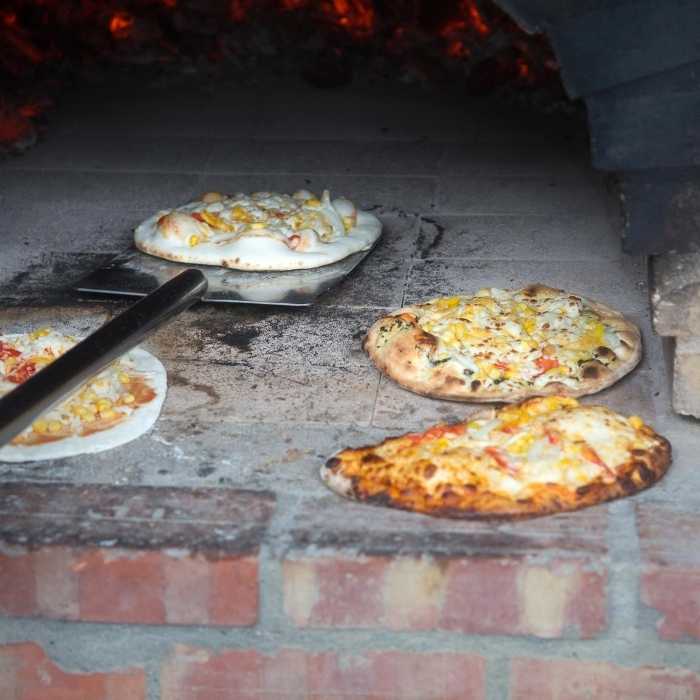 A professional pizza oven with multiple pizzas baking inside.