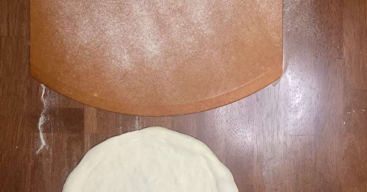 sliding pizza dough onto a pizza peel
