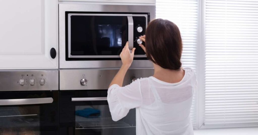 woman using microwave Can Pizza Be Cooked In A Microwave? Yes! Try This Easy Recipe Tonight