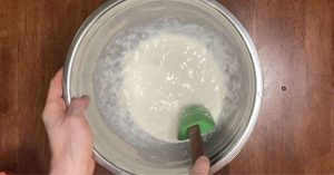 mixing poolish in a large metal bowl