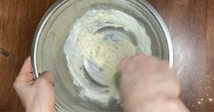 making poolish in a metal mixing bowl