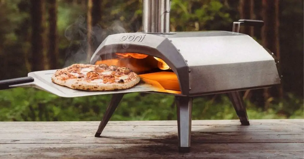 An Ooni Karu 12 pizza oven on a picnic table.