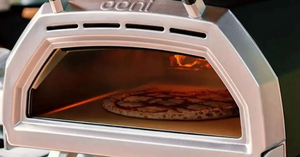 Looking through the insulated glass viewing door of an Ooni Karu 16 multi-fuel outdoor pizza oven.