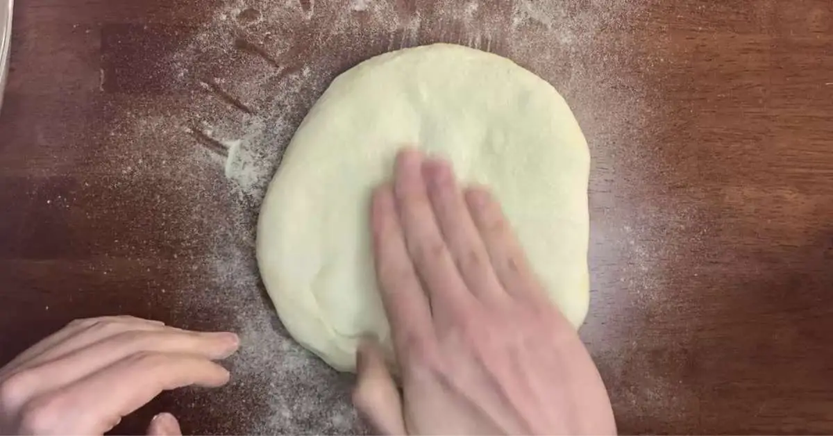 pressing homemade pizza dough