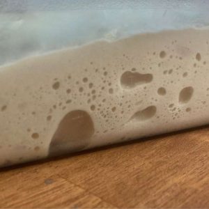 Fermented overnight pizza dough with large air bubbles.
