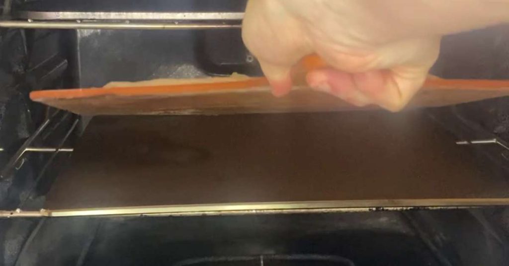 Best Pizza Steels & Baking Stones: Advice From A Homemade Pizza Pro 7 a homemade pizza being launched onto a pizza steel in a home oven