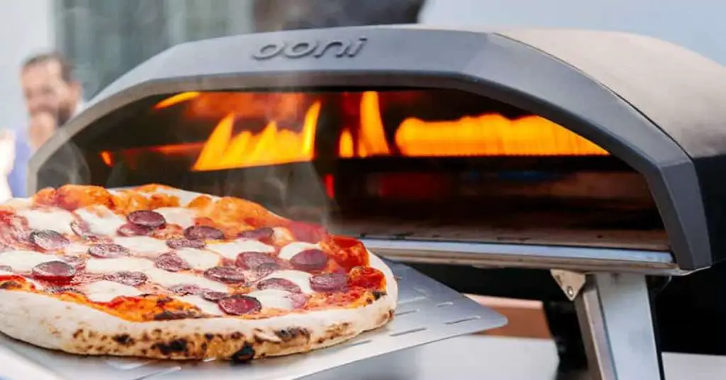 Pepperoni pizza and a gas powered outdoor pizza oven
