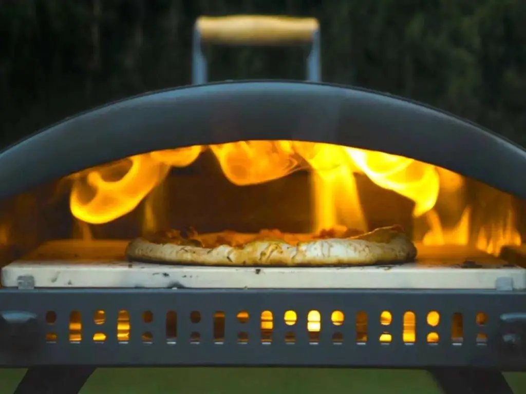 The Bertello Grande 16 pizza oven fired up, looking inside where a pizza is cooking.