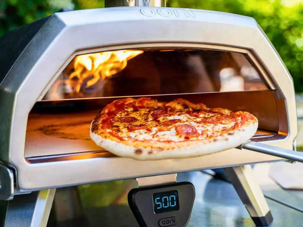 The Ooni Karu 16 featuring the optional "pizza door" accessory which allows for launching and adjusting the pizza without having to open the door.