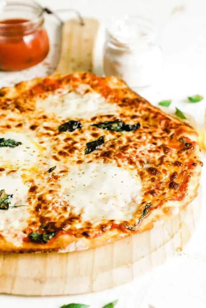 10 Delicious Thin Crust Pizza Recipes You Have To Try 4 A freshly baked margherita pizza with golden crust and melted mozzarella on a wooden pizza peel.