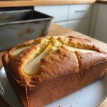 Delicious homemade pear cake on a plate, showcasing golden-brown crust and sliced pears on top, perfect for an afternoon treat.